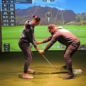 Golf instructor teaching student indoor swing technique